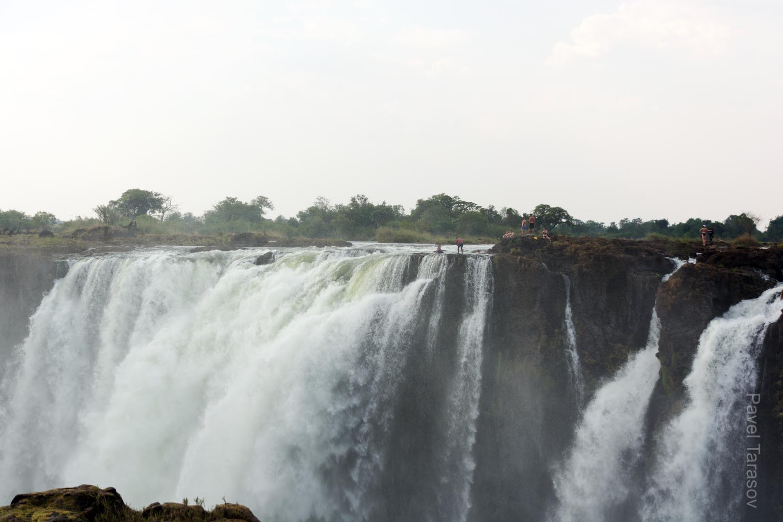 Место, где купаются люди - Devis Pool. В большую воду здесь везде течет вода, а в малую, как на фото образуется остров (остров Livingstone) с которого можно ходить купаться в естественный бассейн на основной струе водопада. Остров частный и искупаться стоит около 100$