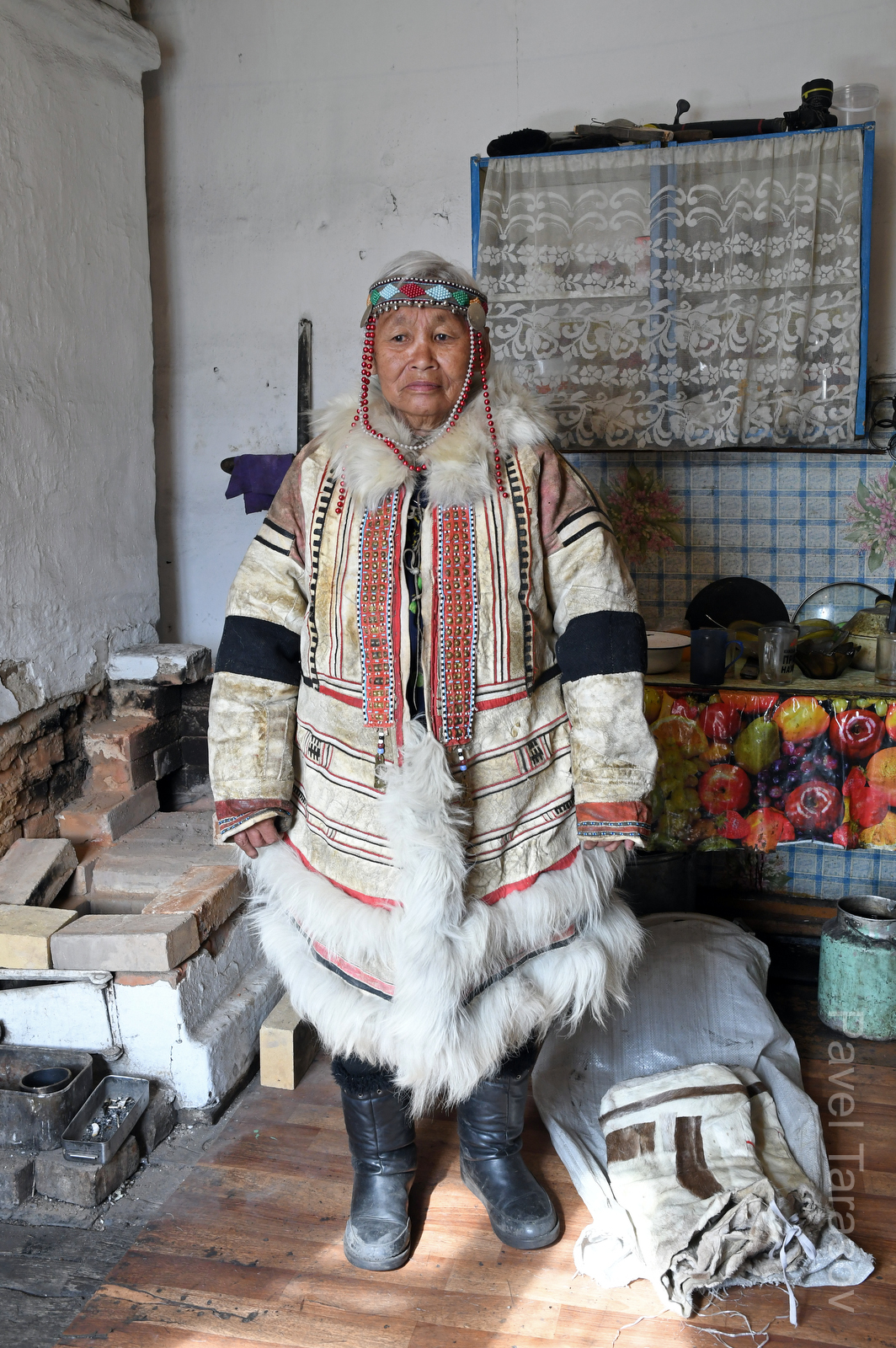 Нганасаны - одна из малочисленных народностей Таймыра, их сейчас около 500. Они были кочевниками-оленеводами до прихода советской власти. Сейчас их становится все меньше, культура исчезает, сами они ассимилируются. 

Перед вами Яроцкая Мария Дюнтовна, мастерица рукодельница из Волочанки. На ней парка собственной работы, расшитая национальными узорами, сделанная целиком из оленя. 